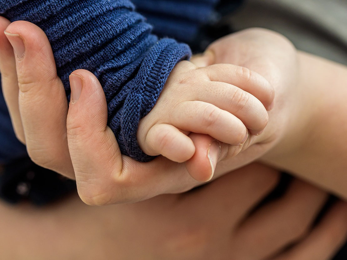 Kinderhand in der Hand eines erwachsenen Menschen. (c) Foto: Pixabay